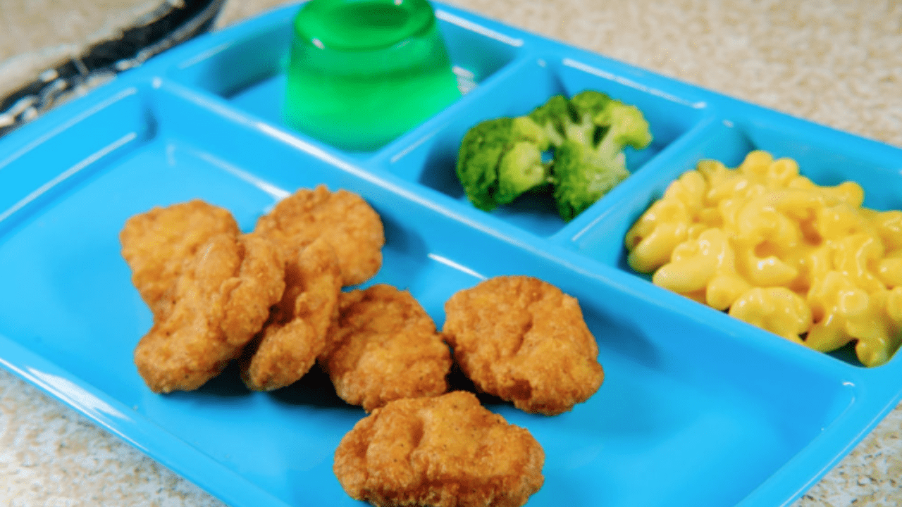School cafeteria lunch of chicken nuggets and mac and cheese on a blue tray